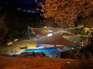 a string of lights over a pool at night at Lago Amor de Valle Glamping in Villa de Juárez +32 photos
