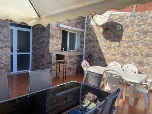 a dining room with a table and white chairs at La belle vue in Bologuine Ibnou Ziri