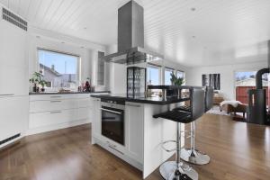 eine Küche mit weißen Schränken und einem Herd mit Backofen in der Unterkunft Perfect house in Henningsvær with sea-view in Henningsvær + 33 Fotos