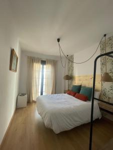 a bedroom with a bed with red and blue pillows at Apartamento CASA PEPA in Antequera