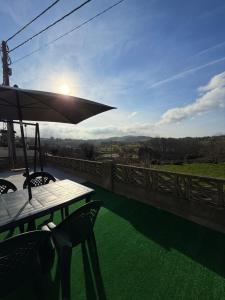 a table and chairs with an umbrella on a balcony at La casuca de Candela in Santillana del Mar