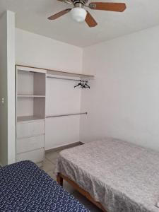 ein Schlafzimmer mit zwei Betten und einem Deckenventilator in der Unterkunft Departamento En Acapulco Diamante con Alberca, Camastros y Hermosos Jardines in Acapulco