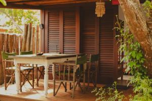 a table and chairs in front of a house at Vulva Caraíva Hostel e Pousada para Mulheres in Caraíva