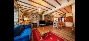 ein Wohnzimmer mit einem blauen Sofa und einem Tisch in der Unterkunft Quirky Mountain Cottage in Pontardawe