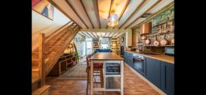 eine große Küche mit blauen Schränken und Holzdecken in der Unterkunft Quirky Mountain Cottage in Pontardawe + 16 Fotos