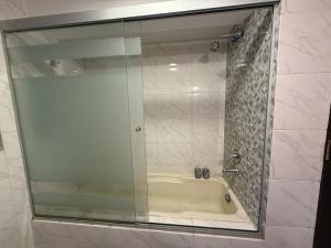 a shower with a glass door and a tub at 1D apartment in the best area of La Paz in La Paz