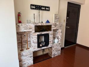 a living room with a stone fireplace at 1D apartment in the best area of La Paz in La Paz