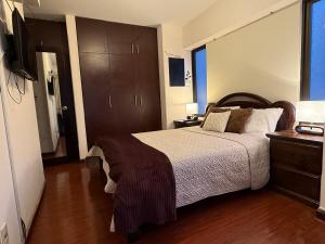 a bedroom with a large bed and a television at 1D apartment in the best area of La Paz in La Paz