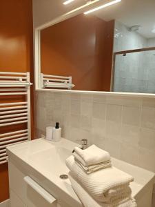 a bathroom with a white sink and a mirror at Grand appart 2 chambres - Hyper centre - Calme in Chinon +10 photos