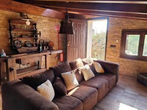a living room with a brown couch in a room at Rifugio della Pace Piano terra e Primo Piano in Sant' Isidoro