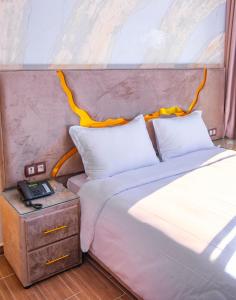 アゼンムールにあるHotel Ibizaのベッドルーム1室(ベッド1台、ナイトスタンドの電話付)