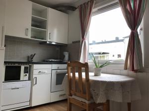 a kitchen with a table with a chair and a window at Cozy small bedroom flat in Trondheim