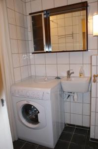 a bathroom with a washing machine and a sink at Cozy small bedroom flat in Trondheim
