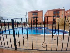a metal fence with two pools in front of a building at Cop30 Apartamento completo in Ananindeua
