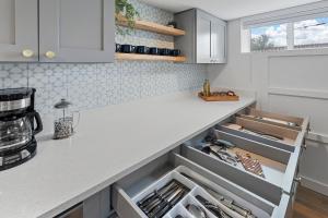 eine Küche mit weißen Schränken und einer Arbeitsplatte in der Unterkunft Urban Hideaway - Charming 2 Bedroom Apartment Close to Denver's Best Attractions in Denver