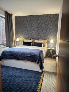 a bedroom with a large bed with a blue blanket at Wellness Spa Suite by the Opera in Budapest