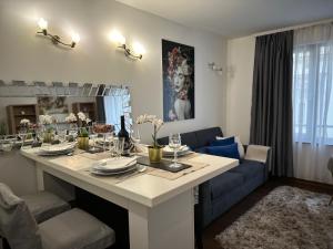 a living room with a table and a blue couch at Wellness Spa Suite by the Opera in Budapest