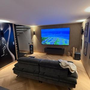 un soggiorno con divano e TV a grande schermo di Maison privative avec piscine intérieure, spa, sauna, cinéma et billard a Échenoz-la-Méline Altre 29 foto