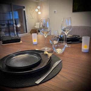 un tavolo di legno con sopra piatti e bicchieri da vino di Maison privative avec piscine intérieure, spa, sauna, cinéma et billard a Échenoz-la-Méline