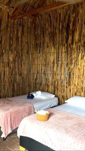 a room with two beds and a wooden wall at Mayapo Liwa in Manaure