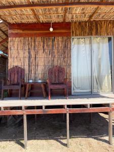 two chairs and a table in front of a house at Mayapo Liwa in Manaure
