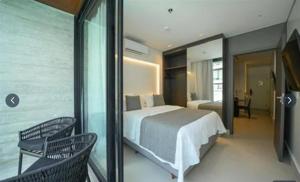 a bedroom with a bed and a balcony with chairs at PORTO ALTO RESORT - GAV - Praia do Muro Alto in Ipojuca +4 photos