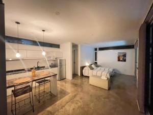 a bedroom with a bed and a kitchen with a table at Casa en Vistalba para dos personas con yacuzzi de temporada en la terraza in Ciudad Lujan de Cuyo