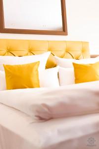 BorkheideにあるHotel Fliegerheimの黄色い枕付きベッドのクローズアップ
