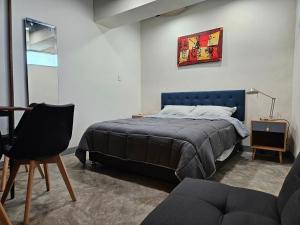 a bedroom with a bed and a table and a chair at Relaxed and private in Jiquilpan de Juárez