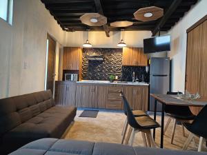 a living room with a couch and a table and a kitchen at Relaxed and private in Jiquilpan de Juárez +9 photos
