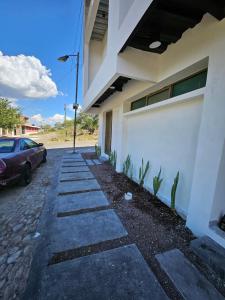 a sidewalk in front of a building with a car at Relaxed and private in Jiquilpan de Juárez