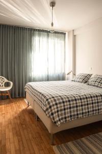 een slaapkamer met een bed met een geruite deken bij Apartamento Mira Foz in Matosinhos