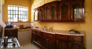 una cucina con armadi in legno e piano cottura di House Colonial Style a La Hatte