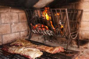 two pieces of meat cooking in a brick oven at Serendipia Santa Ana in Santa Ana