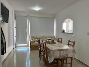 a dining room with a table and chairs and a couch at Alojamiento Puerto Madryn a metros del Mar in Puerto Madryn