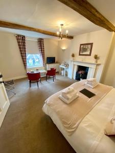 a bedroom with a large bed and a living room at Antlers Bed and Breakfast in Abbots Bromley