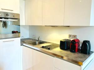 a kitchen with white cabinets and a sink at Le Garib in Nice