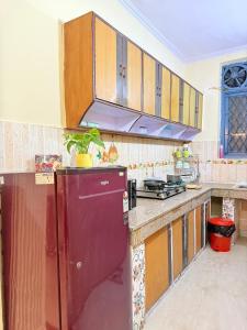 a kitchen with a red refrigerator and wooden cabinets at Boho by Ikhomes 2BHK Apartment New Delhi in New Delhi +31 photos