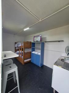 a room with a kitchen and a room with bunk beds at Hospedagem Caminho do Parque in Vacaria