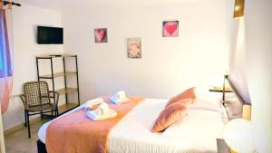 a bedroom with a bed with two towels and a chair at Auberge de Cannedda in Sari Solenzara +24 photos