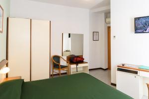 a small room with a green bed and a desk at Hotel Italie et Suisse in Stresa