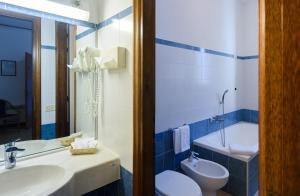 a bathroom with a sink and a toilet and a tub at Hotel Italie et Suisse in Stresa +33 photos