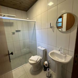 a bathroom with a toilet and a sink and a mirror at A Estalagem Pousada in Monteiro Lobato +19 photos