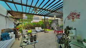 a living room with a conservatory with a lot of plants at Habitaciones Coyoacan (UNAM) in Mexico City