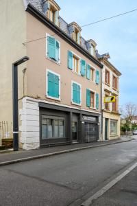 a building with blue windows on a city street at Le Jules in Montbéliard