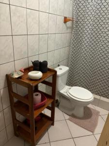 a bathroom with a toilet and a table with a shelf at Gite Oiseau du Paradis in Le Marin +4 photos