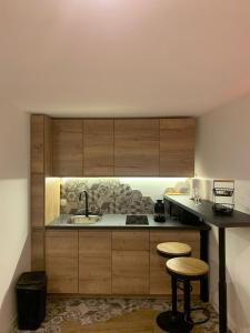 サン・シャモンにあるLove Room, studio Woody Spa , Balnéoのキッチン(木製キャビネット、シンク、スツール付)
