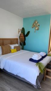 a bedroom with a large bed with a blue wall at Suite Caraïbes 1 - Superbe Studio Cosy in Les Trois-Îlets