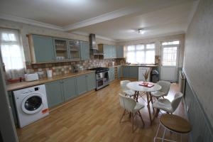 a kitchen with green cabinets and a table and chairs at The Oaks Place in Hanworth