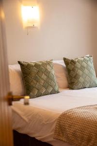 a bedroom with a bed with white sheets and pillows at Y Caban in Cemaes Bay
